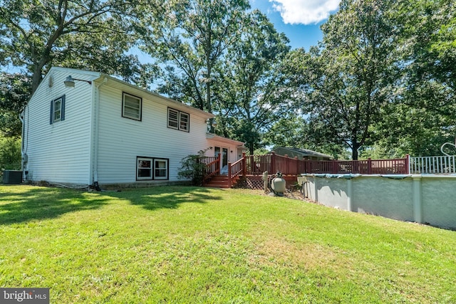 back of house featuring central AC unit and a yard