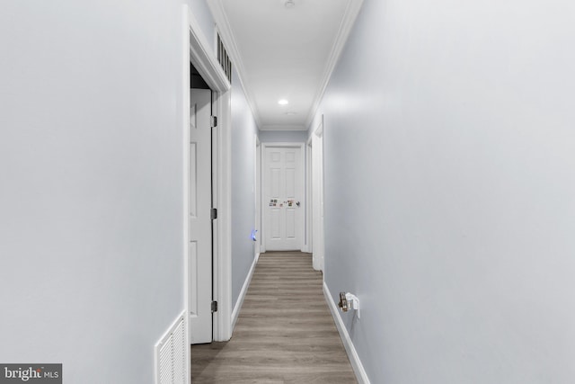 corridor featuring crown molding and light hardwood / wood-style floors