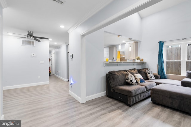 living room featuring light hardwood / wood-style flooring, ceiling fan, and crown molding