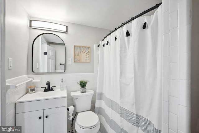 bathroom with tile walls, vanity, toilet, and a shower with shower curtain