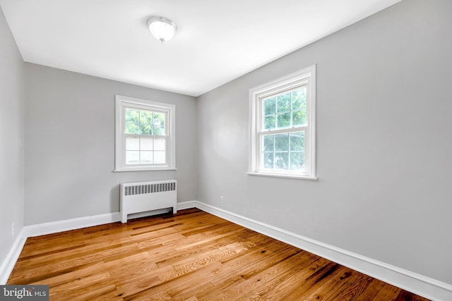 empty room with radiator and light hardwood / wood-style floors