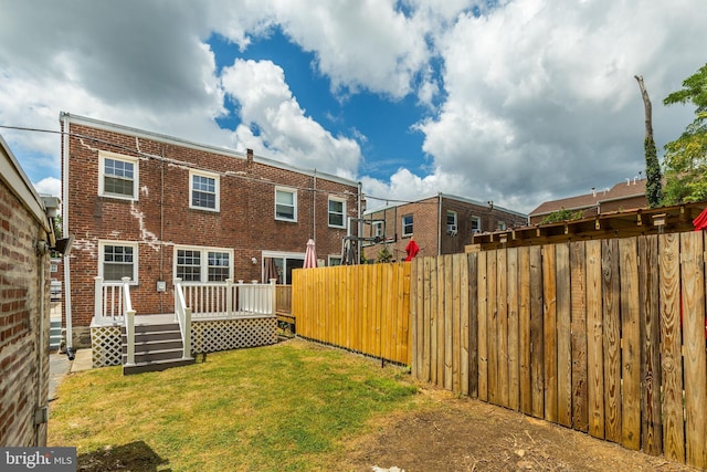 back of house with a yard and a deck