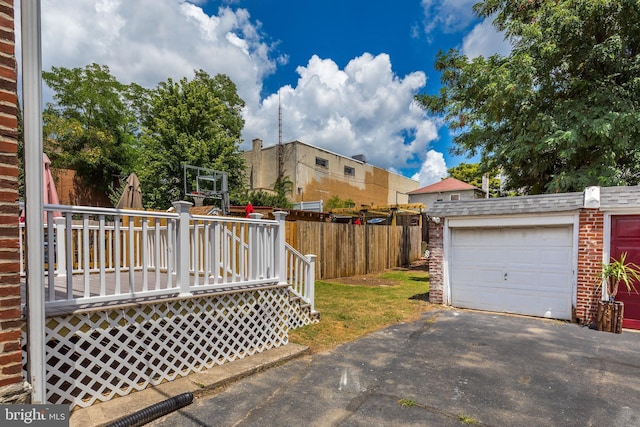 view of yard featuring a garage, an outdoor structure, and a deck