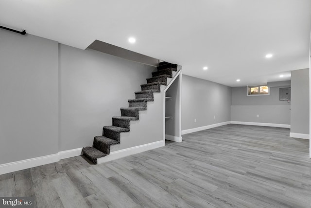 basement with light hardwood / wood-style flooring