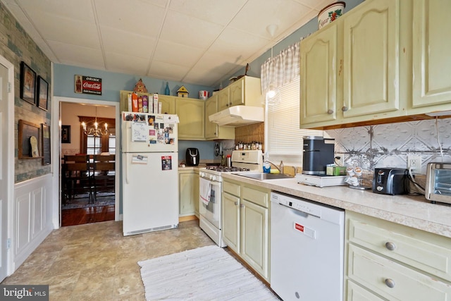 kitchen with white appliances, backsplash, an inviting chandelier, and sink