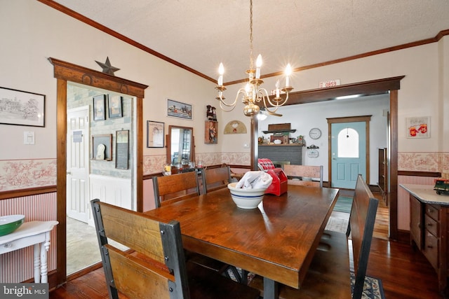 dining room with a notable chandelier, a fireplace, dark hardwood / wood-style floors, and a textured ceiling