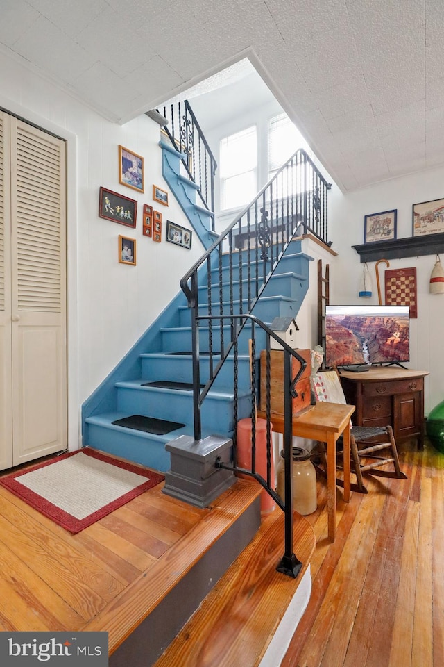 staircase with hardwood / wood-style flooring and a textured ceiling