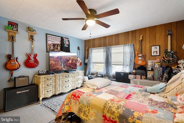 bedroom with wooden walls and ceiling fan