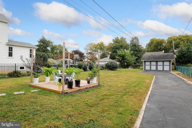 view of yard featuring a garage, an outbuilding, and a deck