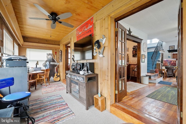 interior space featuring ceiling fan, wood walls, and wood ceiling