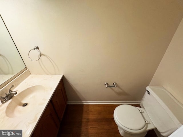 bathroom featuring wood-type flooring, vanity, and toilet