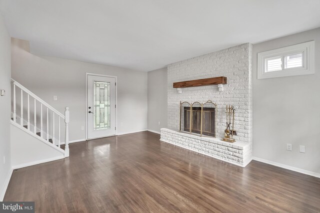 unfurnished living room featuring a fireplace and dark hardwood / wood-style flooring