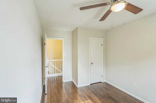 unfurnished bedroom with ceiling fan and dark hardwood / wood-style flooring