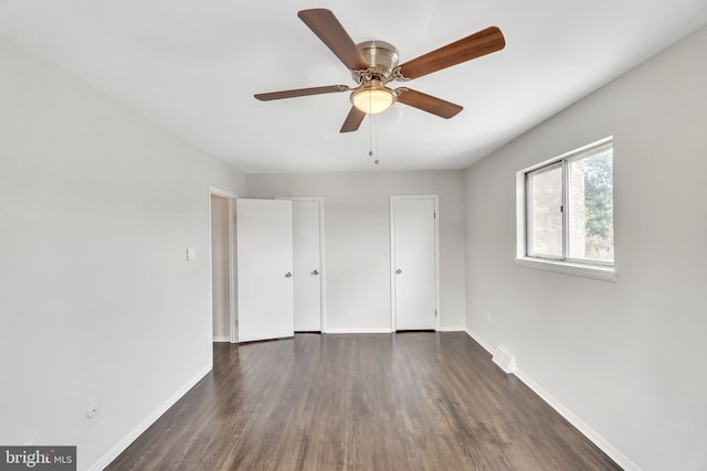 unfurnished bedroom featuring ceiling fan and dark wood-type flooring