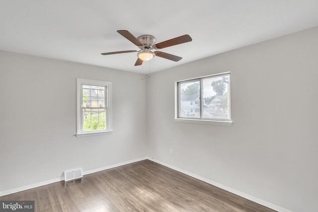 empty room with ceiling fan and dark hardwood / wood-style flooring