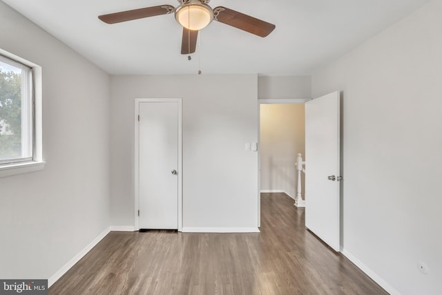 unfurnished bedroom with ceiling fan and dark hardwood / wood-style flooring