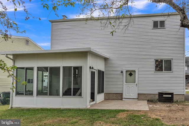 back of property featuring a lawn, cooling unit, and a patio