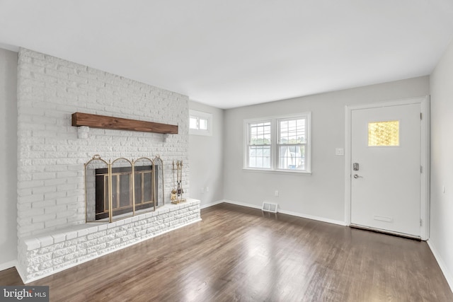 unfurnished living room with a fireplace and dark hardwood / wood-style floors