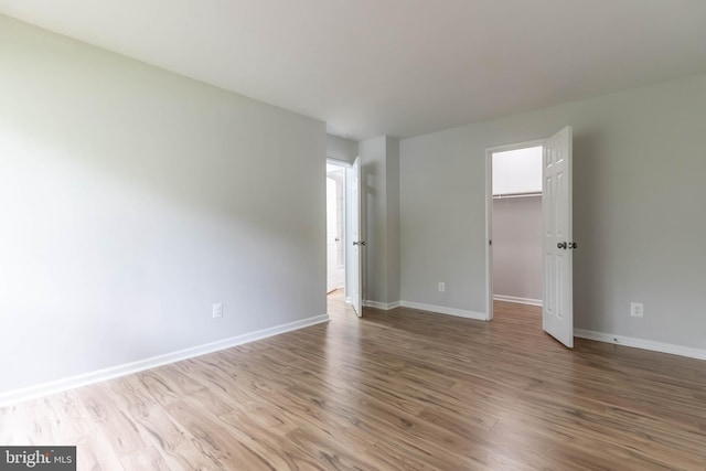 interior space with hardwood / wood-style flooring, a closet, and a walk in closet