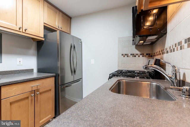 kitchen featuring stainless steel fridge, decorative backsplash, and sink