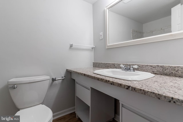 bathroom featuring wood-type flooring, vanity, and toilet