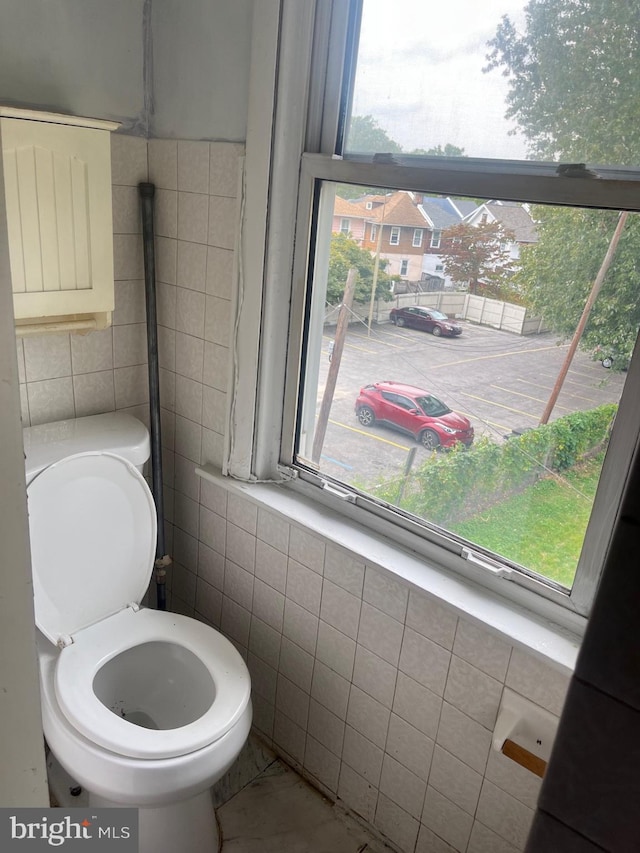 bathroom featuring tile walls and plenty of natural light