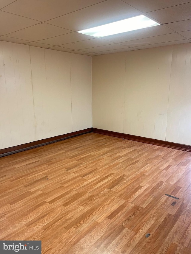 spare room with light wood-type flooring and a drop ceiling