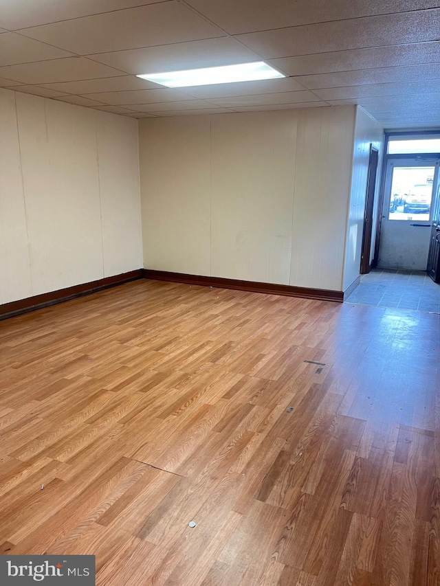 unfurnished room featuring light hardwood / wood-style flooring and a drop ceiling