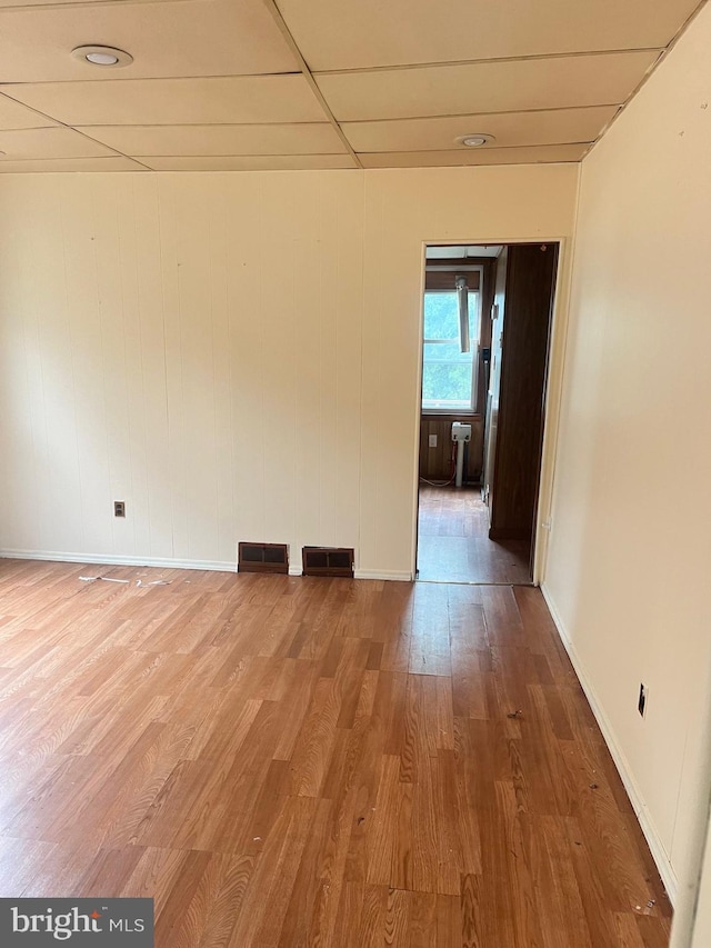 spare room featuring a paneled ceiling and hardwood / wood-style floors