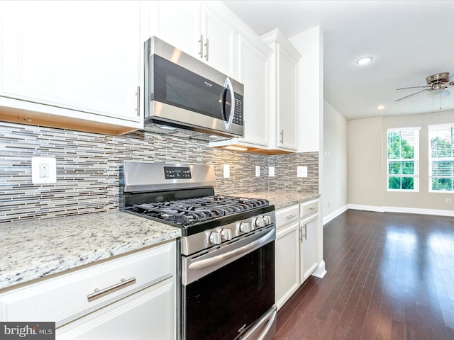 kitchen with white cabinets, appliances with stainless steel finishes, dark hardwood / wood-style floors, and decorative backsplash