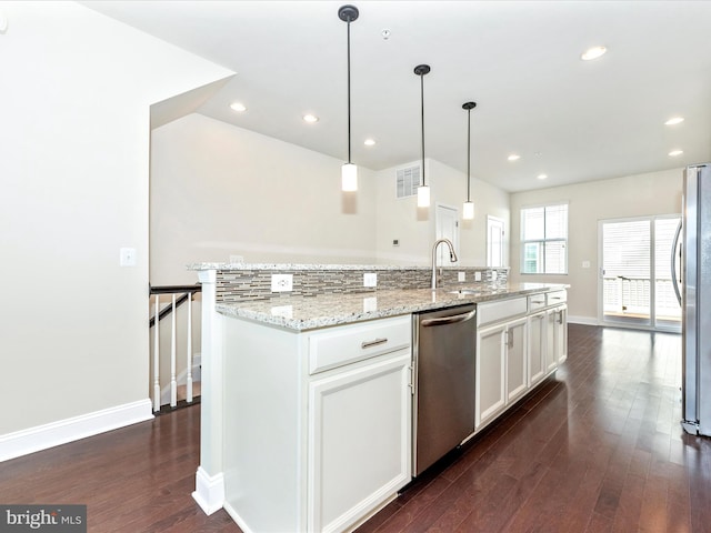 kitchen featuring white cabinets, pendant lighting, sink, a center island with sink, and appliances with stainless steel finishes