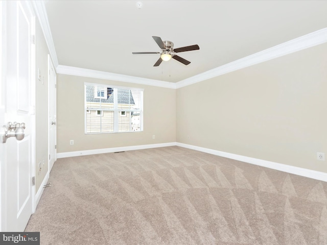 spare room featuring crown molding, ceiling fan, and light colored carpet