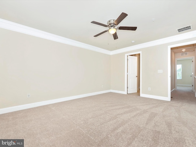 carpeted spare room with ceiling fan and crown molding