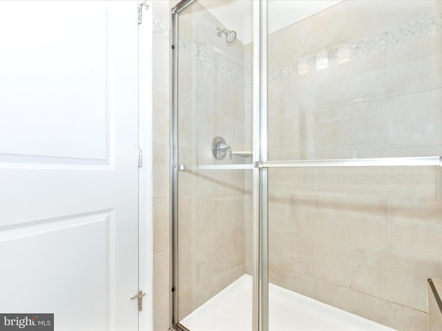 bathroom with a shower with door