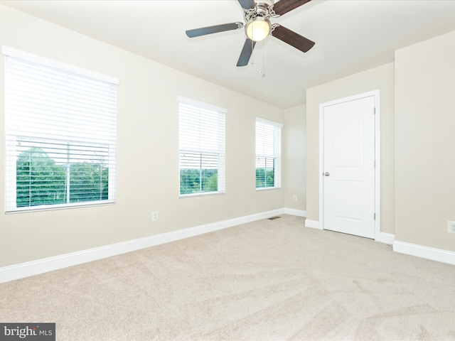 carpeted empty room featuring ceiling fan