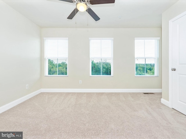 carpeted spare room featuring ceiling fan