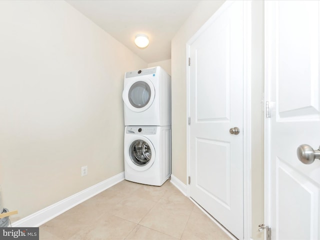 laundry room featuring light tile patterned flooring and stacked washer / drying machine