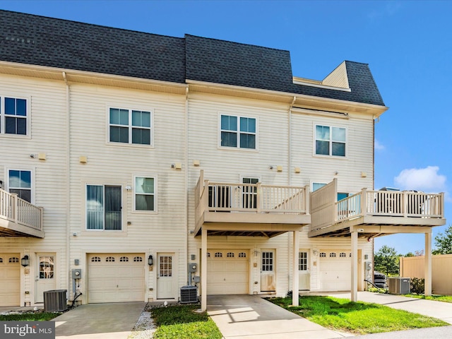 exterior space featuring cooling unit, a balcony, and a garage