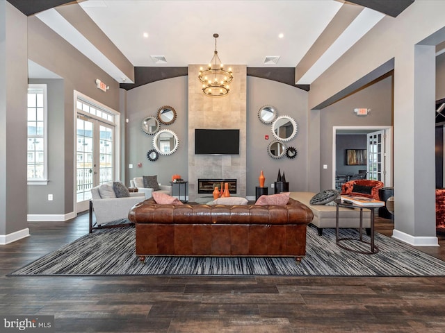 living room with french doors, a notable chandelier, dark hardwood / wood-style flooring, and a tile fireplace