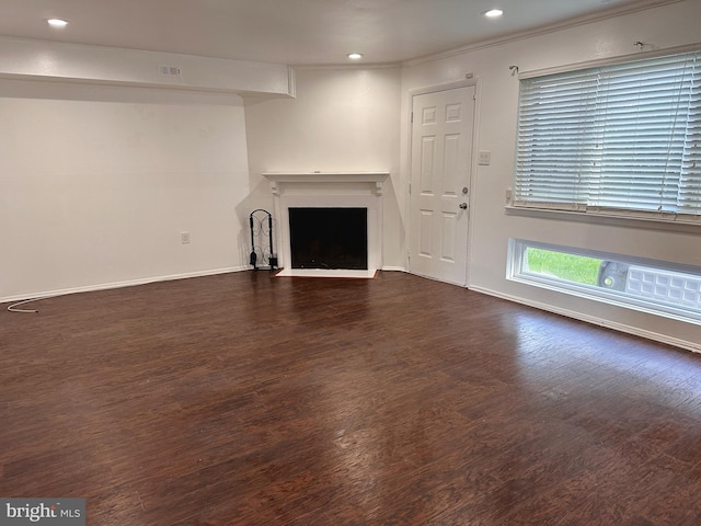 unfurnished living room with dark hardwood / wood-style flooring and ornamental molding