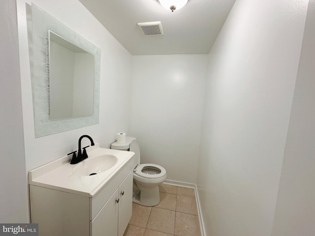 bathroom with tile patterned flooring, vanity, and toilet