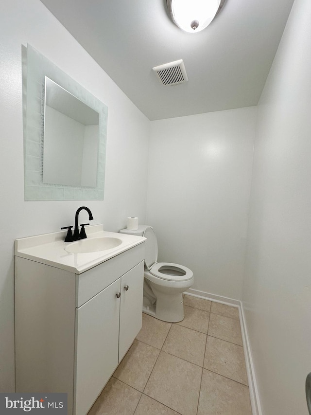 bathroom with tile patterned flooring, vanity, and toilet