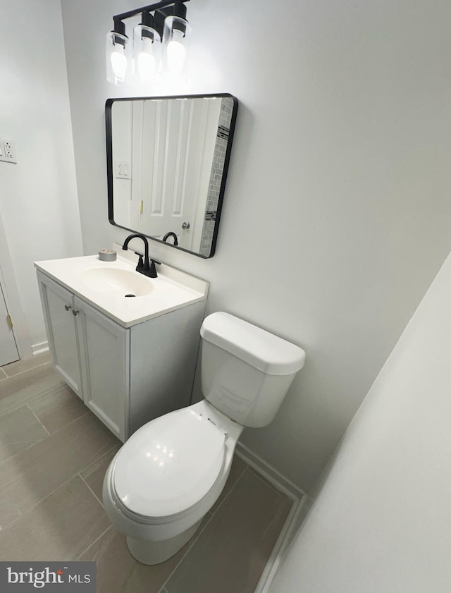 bathroom featuring tile patterned floors, vanity, and toilet