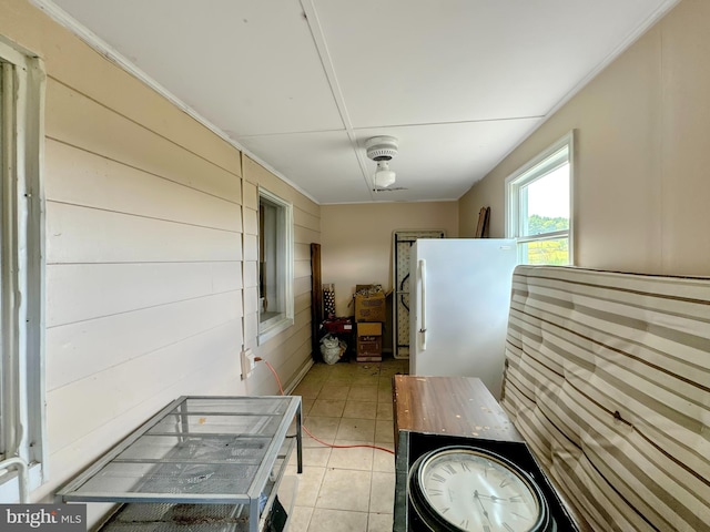 kitchen with light tile patterned floors and white fridge