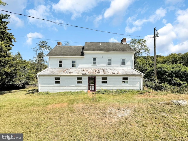 rear view of house featuring a lawn