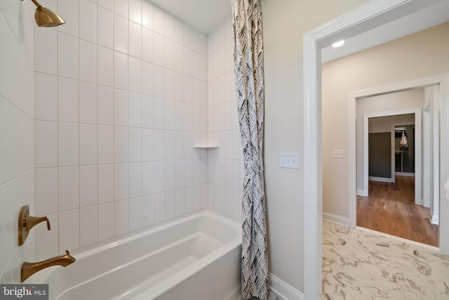 bathroom with wood-type flooring and shower / tub combo