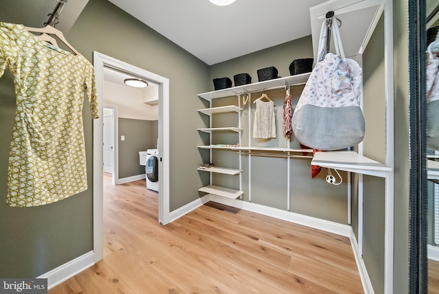 spacious closet with washer / dryer and hardwood / wood-style floors