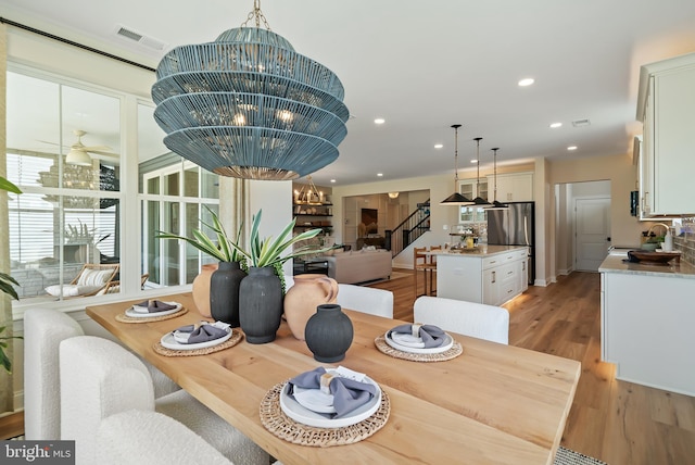 dining room featuring an inviting chandelier, light wood-type flooring, and sink