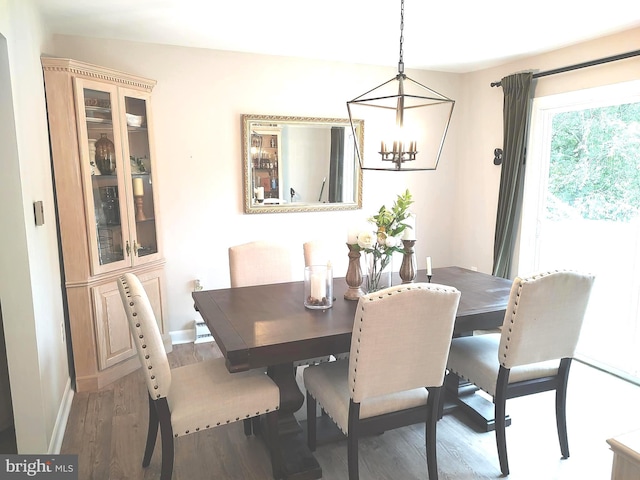 dining space featuring hardwood / wood-style floors and a notable chandelier