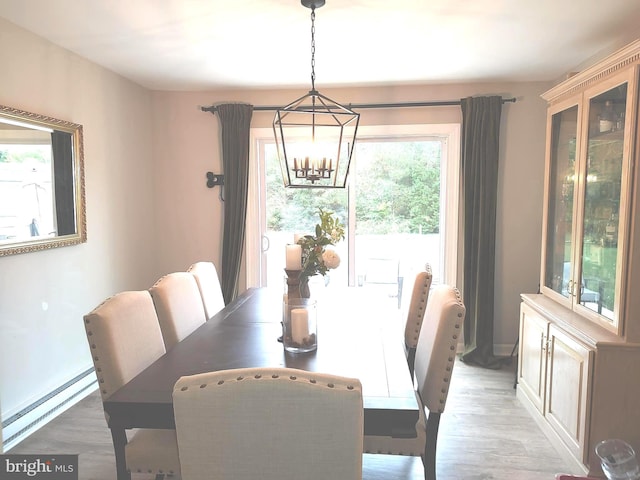 dining space featuring a baseboard radiator, an inviting chandelier, and light hardwood / wood-style floors